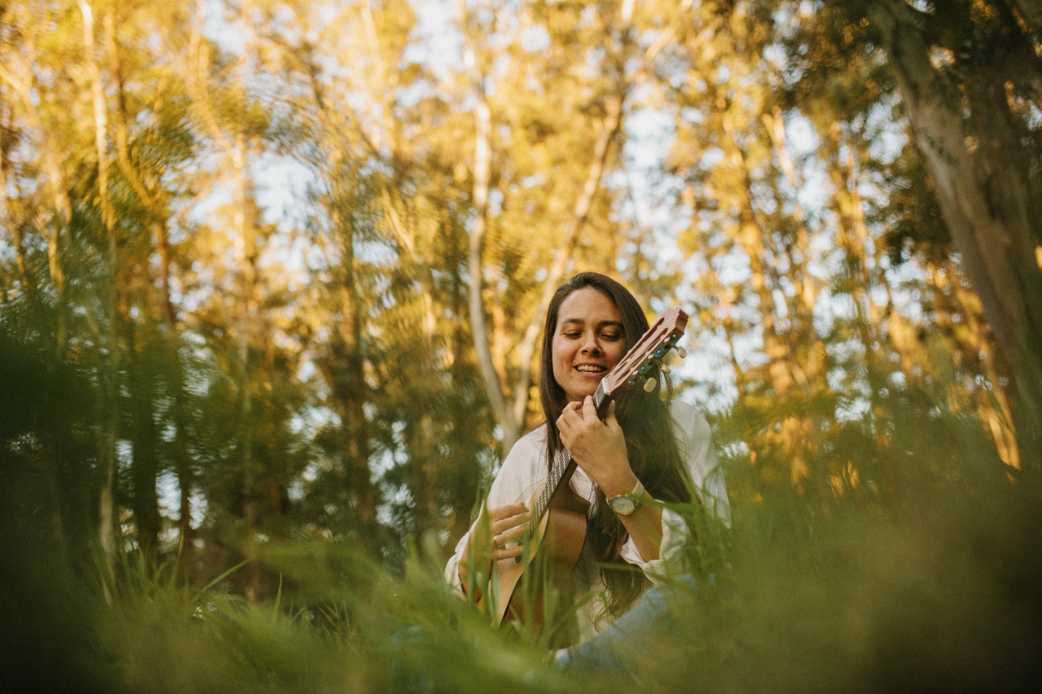 Luna Córdoba tocando la guitarra rodeada de naturaleza